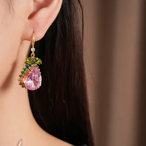 Gros plan exquis de boucles d'oreilles pendantes en zircon rose avec accents colorés