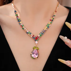 Gros plan d'un collier vintage avec des zircons colorés et un grand pendentif rose en forme de poire.