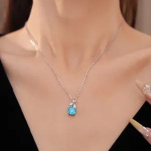 Close-up of elegant silver necklace with blue zircon flower pendant worn on neck
