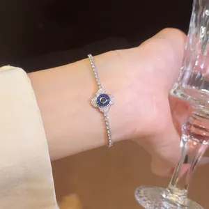 Nahaufnahme eines funkelnden Evil Eye Armbands mit blauen Steinen am Handgelenk