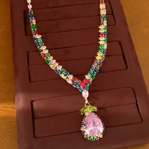 Détail d'un collier vintage en or avec zircons colorés et pendentif goutte rose