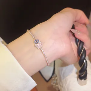 Nahaufnahme des funkelnden Hamsa-Hand- und Evil-Eye-Armbands mit Roségold-Zirkonia-Details.