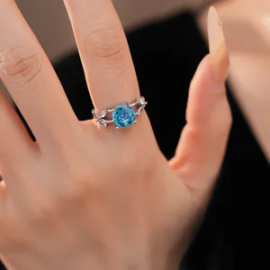 Close-up detail of a silver ring with a blue rose-cut zircon and leaf-shaped stones.