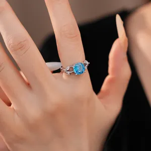 Elegant silver ring featuring a round blue zircon center stone and leaf accents