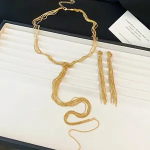 Elegante set di gioielli dorati con collana a nodo e orecchini con nappe lunghe