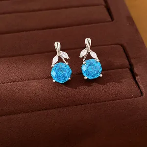 Detailed view of elegant blue zircon flower pendant with silver accents on velvet