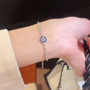 Nahaufnahme des funkelnden Evil Eye Zirkon-Armbands am Handgelenk, eleganter Schmuck.