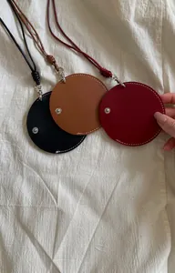 Detailopname van ronde leren hangende kettingen in de kleuren zwart, bruin en bordeauxrood