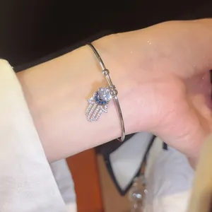 Detailaufnahme eines Hamsa-Armbands mit funkelnden Zirkonien und blauem Evil Eye Design