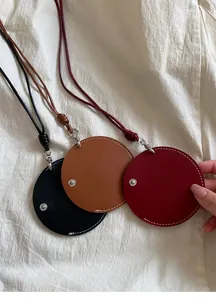 Close-up van ronde lederen brilhouder kettingen in de kleuren zwart, bruin en rood