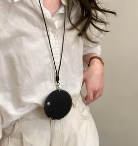 Detailopname van een minimalistische zwarte lederen ronde hanger brillenhouder ketting