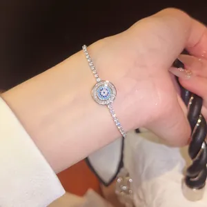 Nahaufnahme eines funkelnden Evil Eye Armbandes mit blauen und klaren Zirkonia am Handgelenk