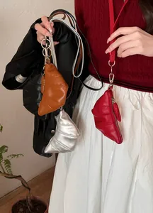 Detailweergave van kleurrijke lederen croissant-vormige muntzakjes aan een modieus model