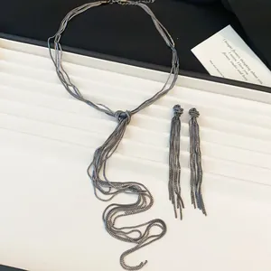 Vue détaillée de l'ensemble collier et boucles d'oreilles à pompons de chaîne noués