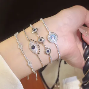 Nahaufnahme von vier silbernen Armbändern mit blauem bösen Blick und Hamsa-Hand mit Zirkonia