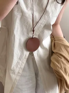 Detailopname van minimalistische bruine leren cirkelhanger ketting als brillenhouder