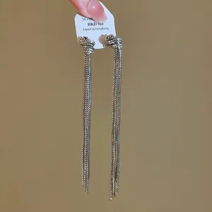 Vue détaillée des boucles d'oreilles élégantes à pompon en chaîne argentée à nœuds