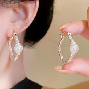 Detailed close-up of vintage French silver hoop earrings with an elegant white pearl