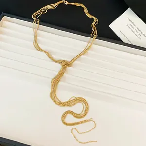 Vue détaillée d'un collier doré multicouche avec un design élégant à nœud et pampilles
