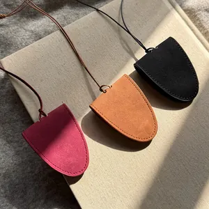 Close-up of luxury suede magnetic eyeglass holders in autumn colors on a textured book