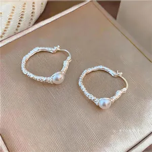 Detailed macro view of French vintage silver hoop earrings with white round pearls