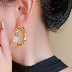 Close-up detail of French vintage gold hoop earrings with a single elegant white pearl.