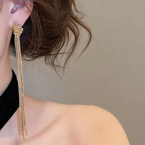 Gros plan détaillé de boucles d'oreilles élégantes à pampilles dorées sur un modèle