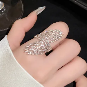 Close-up of sparkling zircon hollow geometric open ring worn on index finger