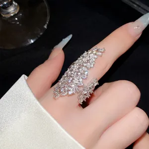 Close-up of sparkling cubic zircon hollow geometric open ring worn on a woman's finger