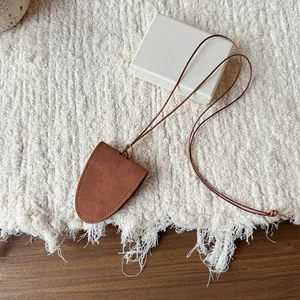 Elegant brown suede neck-hanging glasses clip and magnetic pouch pendant necklace detail view.