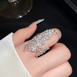 Detailed macro shot of a sparkling zircon hollow geometric open ring on a finger