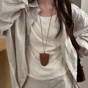 Detailed view of a minimalist brown leather magnetic glasses holder necklace worn as accessory
