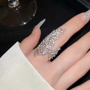 Close-up of a luxurious sparkling zircon-encrusted open ring worn on an index finger