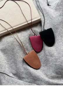 Close-up of three suede magnetic glasses holder necklaces in black, burgundy, and tan tones