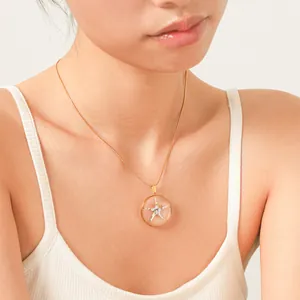 Nahaufnahme einer feinen goldenen Schlangenkette mit einem transparenten Seestern-Anhänger