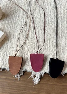 Detail view of three suede magnetic glasses holder necklaces in brown, burgundy, and black
