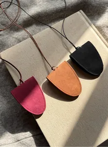 Detail of three magnetic glasses clip pendants in burgundy, tan, and black suede.