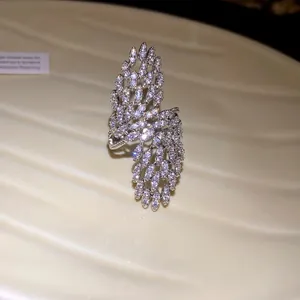 Exquisite close-up of sparkling zircon feather wing wrap ring with silver plating