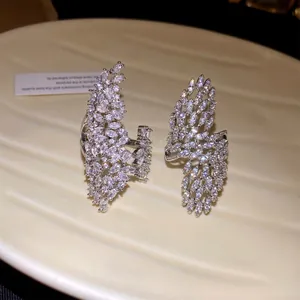 Macro detail of two sparkling cubic zirconia leaf-shaped open rings on a display tray