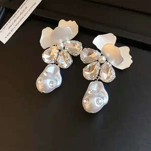 Detailed view of elegant flower earrings with sparkling rhinestones and pearls