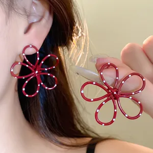 Close-up of red metal flower earrings with white polka dots for a sweet style