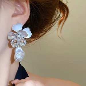 Close-up of elegant French-style floral earring with rhinestones and baroque pearl
