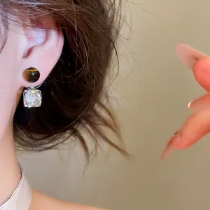 Detailed close-up view of Maillard style zircon geometric dangle earrings on ear