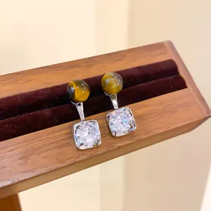 Detail view of Maillard style earrings featuring tiger eye beads and square zircon stones