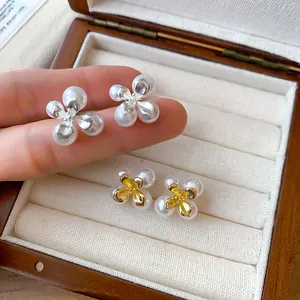 Dettaglio degli eleganti orecchini a lobo a fiore di perle in finitura oro e argento