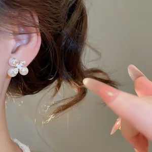Primo piano di un elegante orecchino a bottone a forma di fiore di perla con luce calda