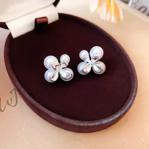 Primo piano di eleganti orecchini a fiore in argento con perle bianche in scatola.