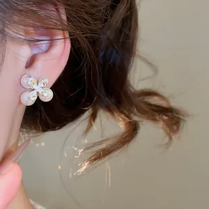 Dettaglio ravvicinato che mostra l'elegante design degli orecchini a fiore con perle