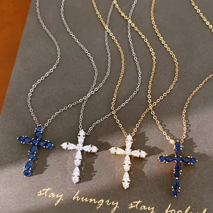 Cuatro collares de cruz bañados en oro de 18k con detalles de circonitas azules.
