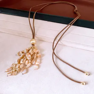 Gros plan d'un collier de style ethnique rétro avec pendentif à pampilles en coquillage